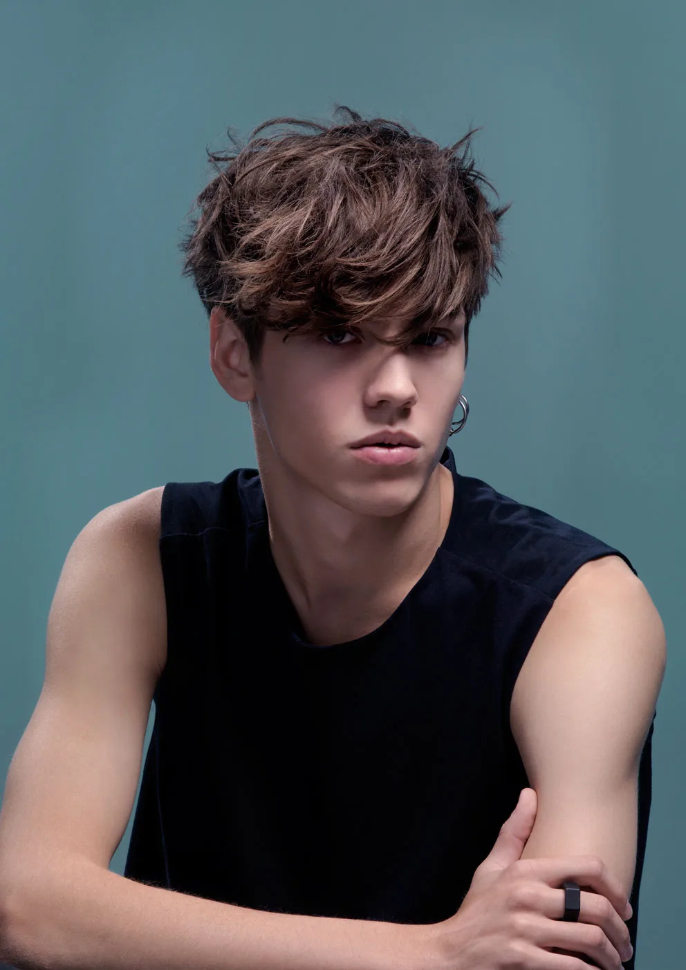 Editorial — young man, messy textured brown fringe, teal studio