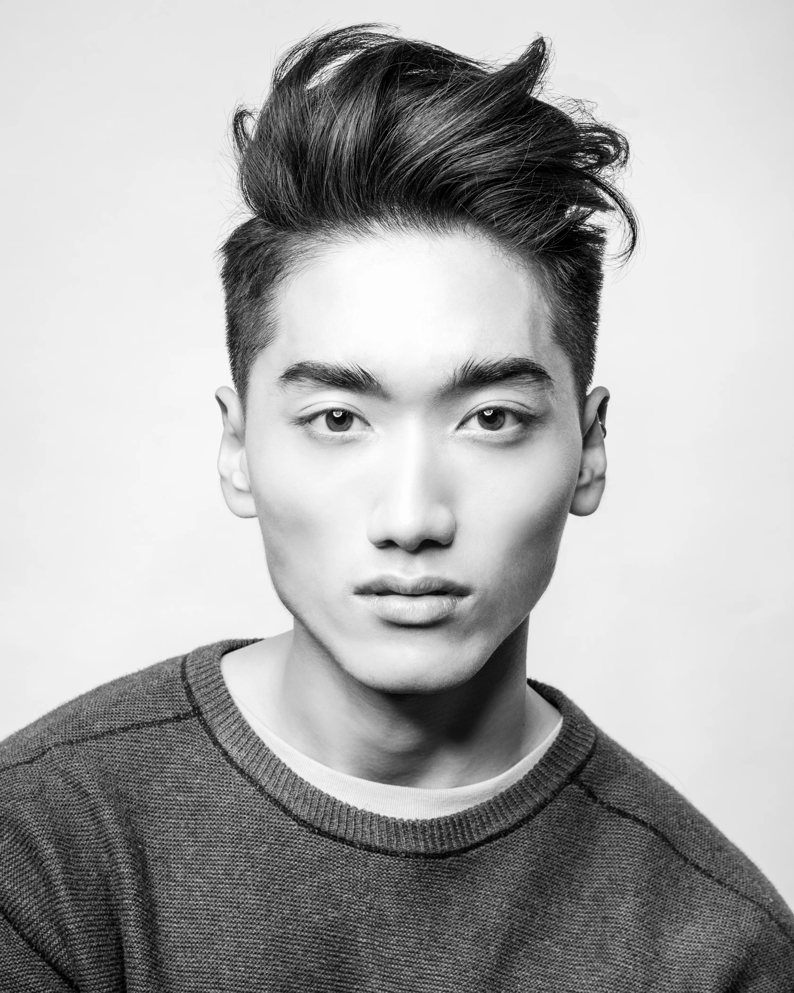 Editorial B&W — man, big voluminous slicked pompadour, grey sweater