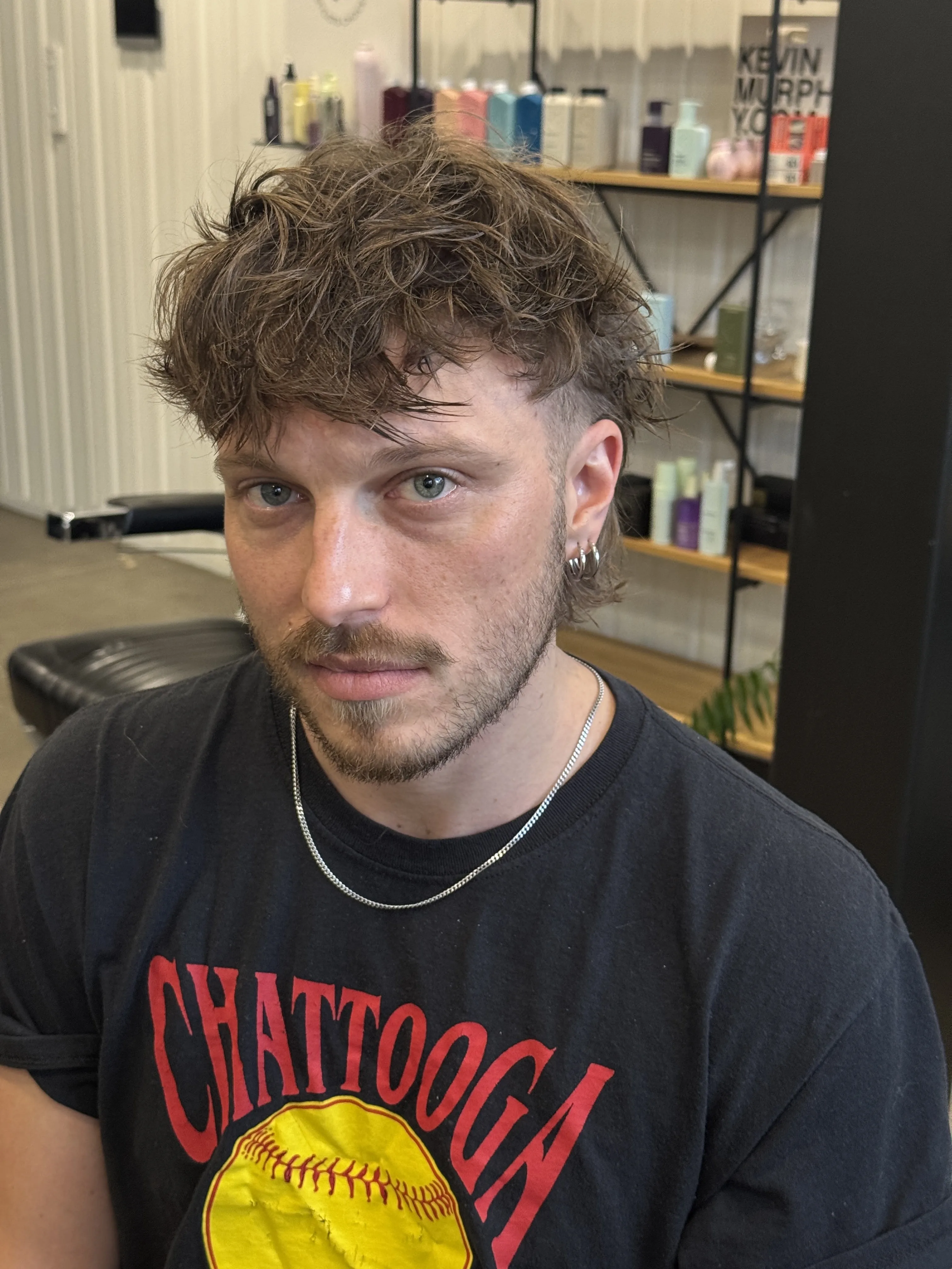In-salon client — man, tousled wavy crop, in front of the Kevin Murphy product wall